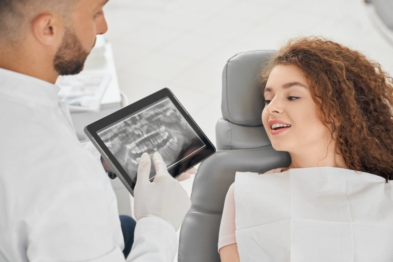 a dentist explains about dental implants to a girl