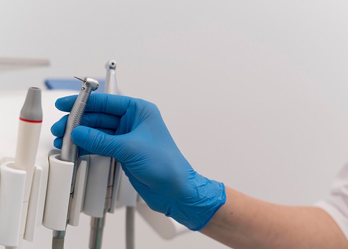 Dentist-with-latex-glove-handling-dental-equipment